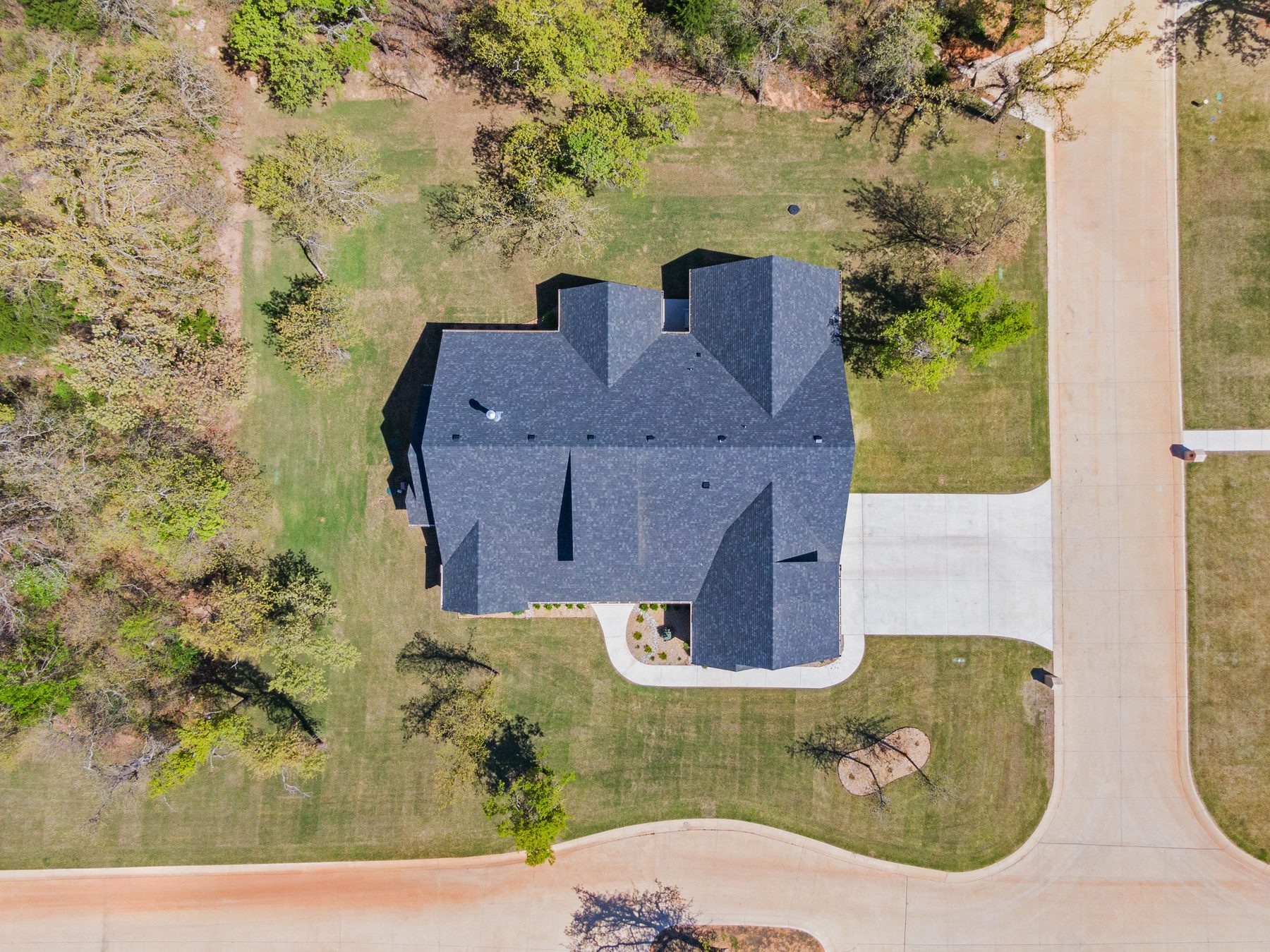 Aerial overhead view of a home's rooftop and lot