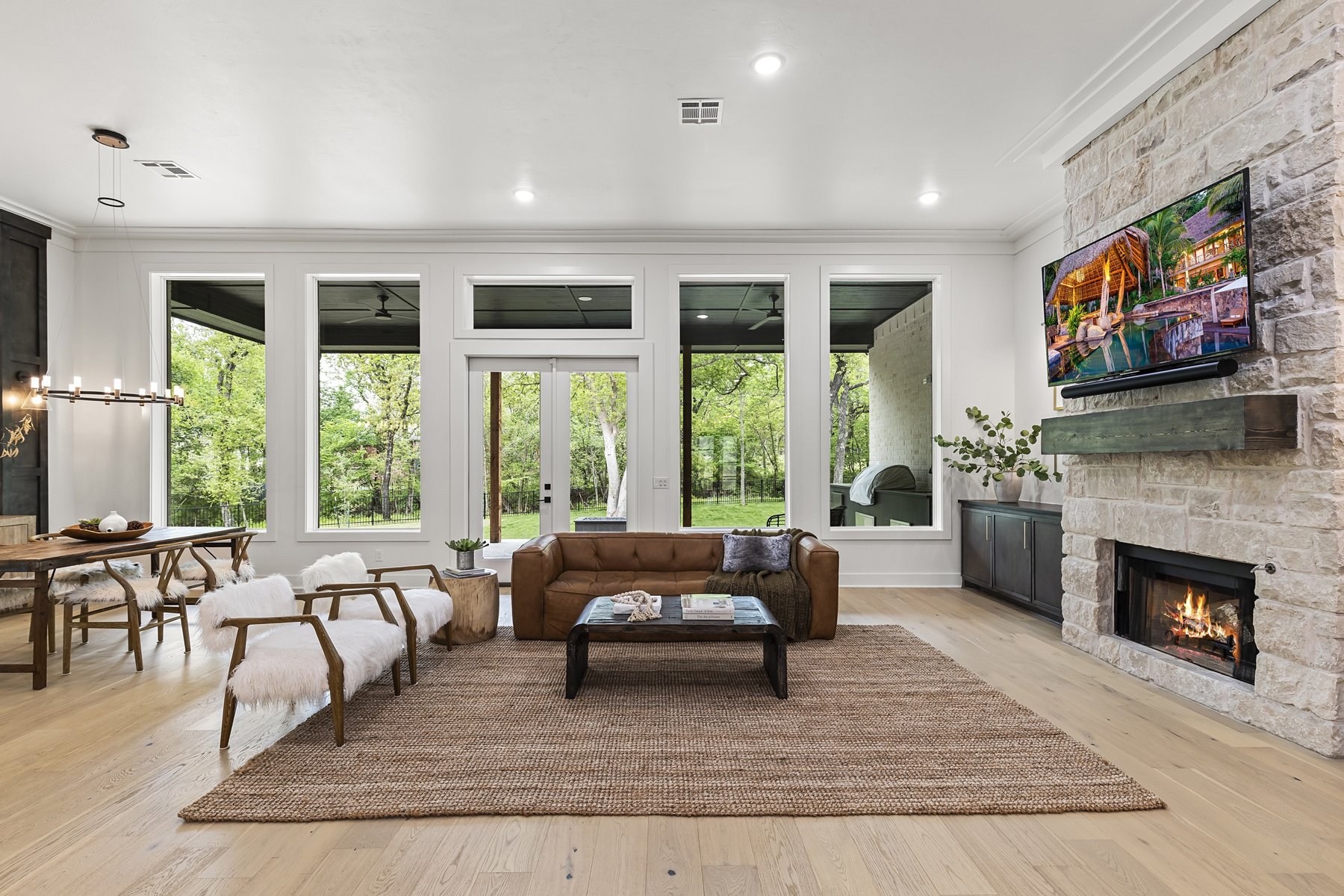 Living room with stone fireplace and wall of windows
